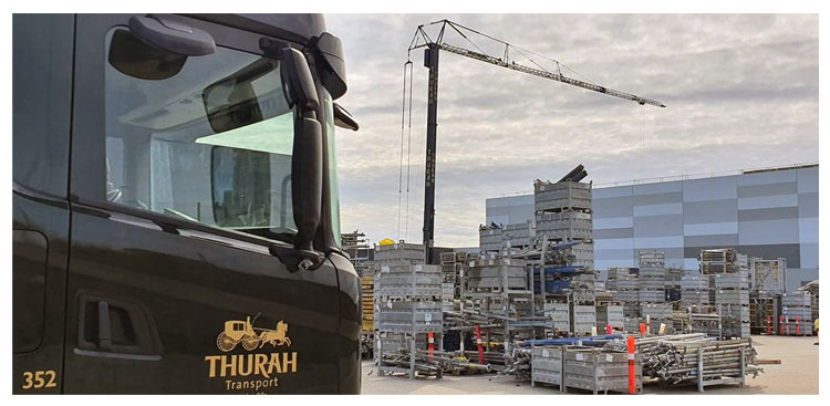 Thurah-lastbil på byggeplads med kran
